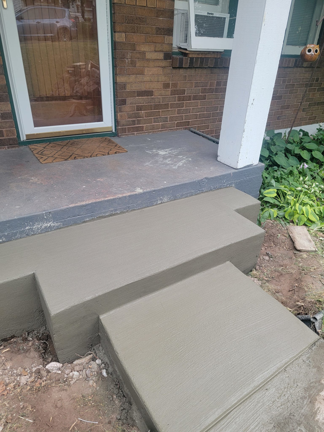 Freshly poured concrete steps leading to a residential entrance, a service by Zambrano Concrete in Duluth, MN.