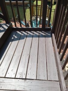Close-up of freshly stained wooden deck boards by Mels Haul & Junk Removal in Raleigh, NC.