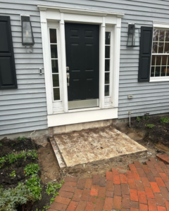 Front door entryway with concrete slab and bricks removed, part of a renovation by Blackcap Handyman in Portland, ME.