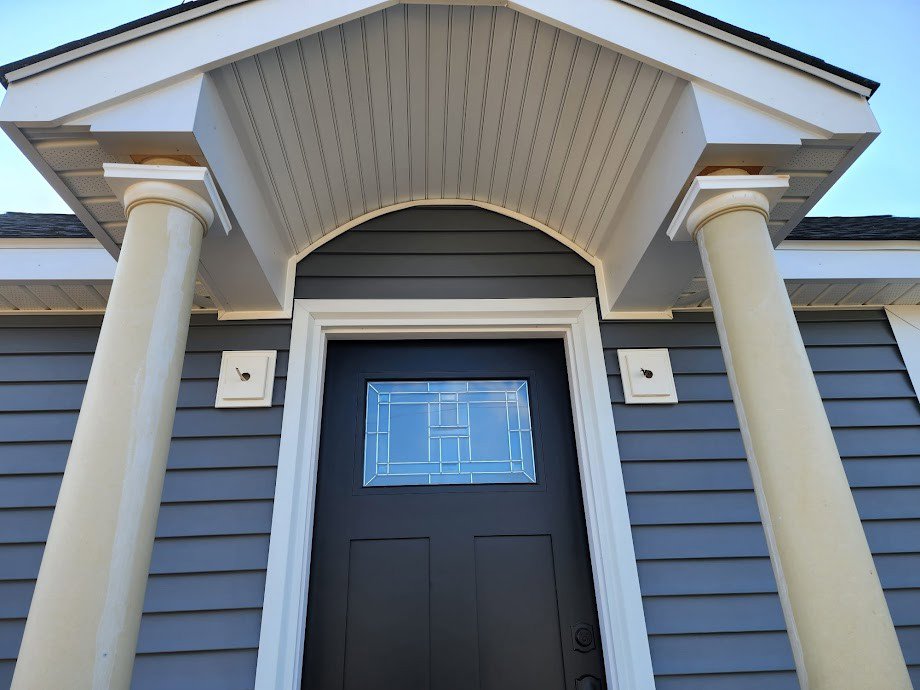 A stylish front door with decorative glass, columns, and exterior trim installed by Santoro Home Improvements in Wallingford, CT.