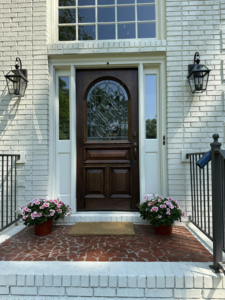 A newly installed front door and exterior lighting fixtures by Parker Painting Company in Edmond, OK.