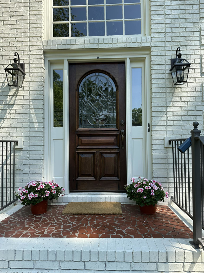 A newly installed front door and exterior lighting fixtures by Parker Painting Company in Edmond, OK.