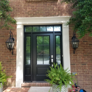 A newly installed black front door with decorative glass and side lights, showcasing work by Paul's Handyman Solutions in Lexington, KY.