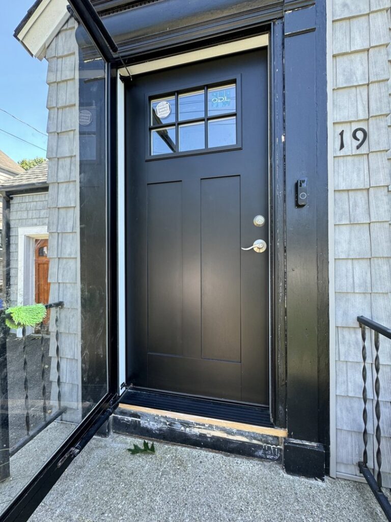 A newly installed black front door with updated exterior trim by Garbatini Contracting in Wallingford, CT.