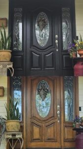 Before and after comparison of a front door, showing a transformation from wood to black paint by Prime Painting in Charlotte, NC.