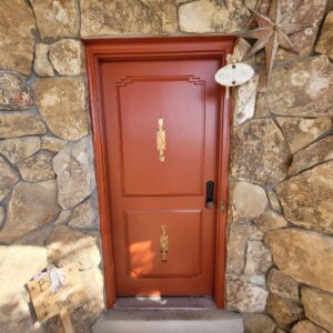 A newly painted orange front door, a service provided by Joe's Handyman Solutions in Ogden, UT.