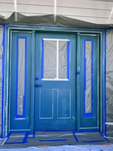 A front door and trim taped off and painted blue by J&R Buezo Painting Services LLC, offering handyman services in Everett, WA