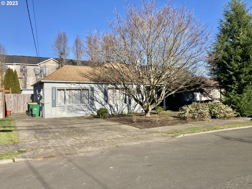 The front exterior of a house with a plain facade and driveway, ideal for curb appeal improvements by Gordon Homes LLC in Portland, OR.