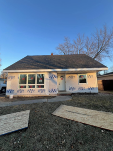 Front of a house undergoing renovation with new roof and windows by Sandoval Contracting & Remodeling in San Antonio, TX.