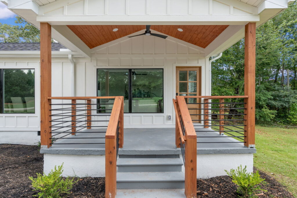 A newly constructed front porch with wooden posts and railings by Heroic Builders LLC in Greenville, SC.