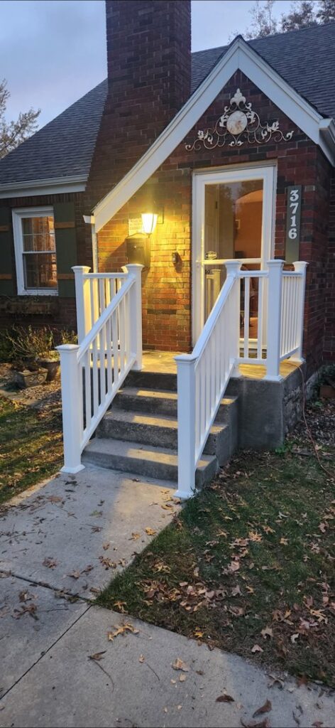 Newly installed white railings on a front porch, enhancing curb appeal and safety, by Go Joe Handyman in Overland Park, KS.