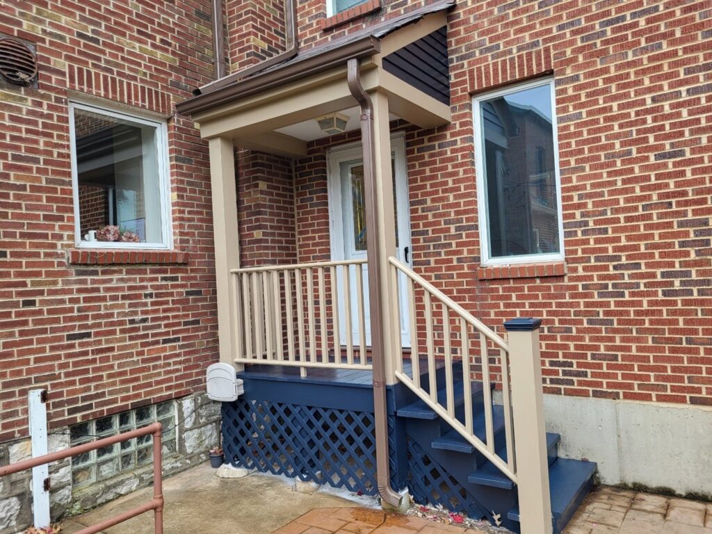 A renovated front porch with new railings and lattice work, painted by McIntosh Construction in Des Peres, MO.