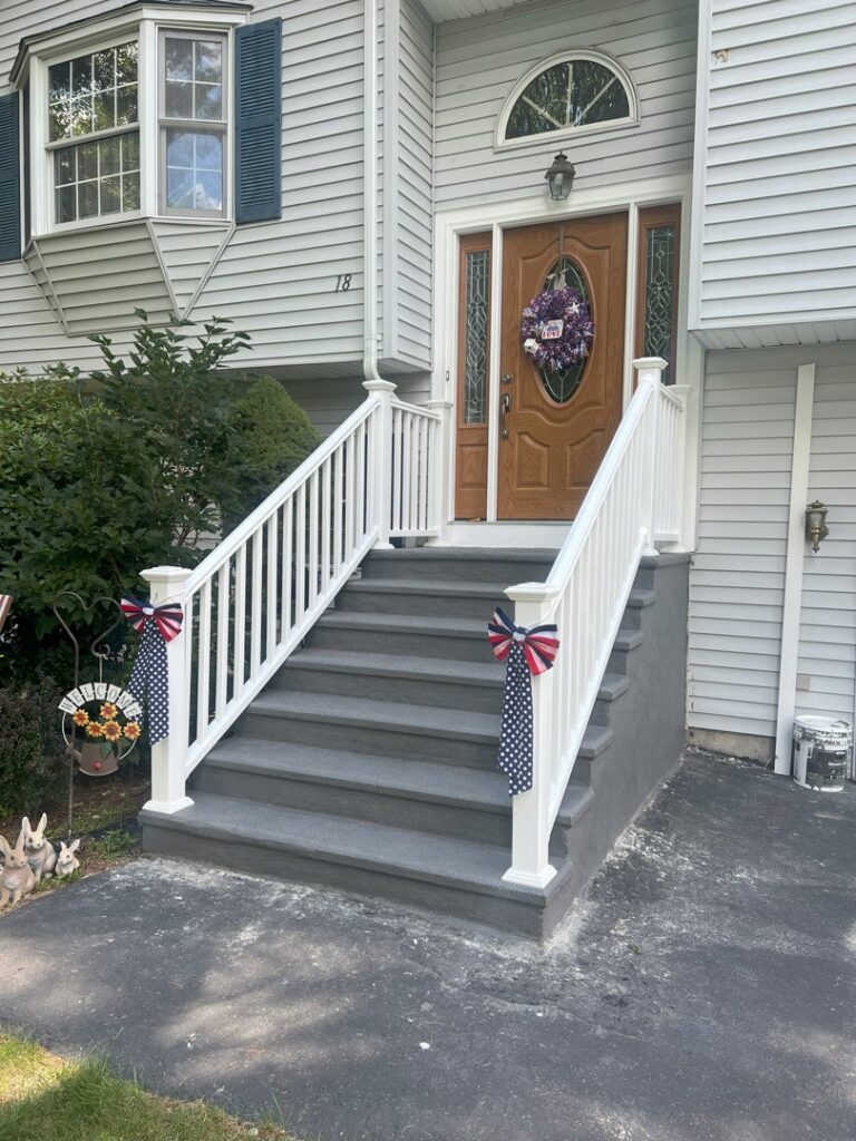 Newly installed front porch steps and white railings by TD Estimating Group LLC in Springfield, MA, enhancing curb appeal.