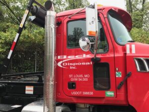 Front and side view of a red disposal truck from Beck Disposal Inc. in St. Louis, MO