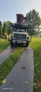Front view of a Middle Tennessee Tree Service truck with a worker in the background in Cookeville, TN.