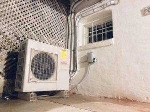 An outdoor Fujitsu HVAC unit installed next to a residential building by Cold Comfort HVAC Services, LLC in Rockville, MD.