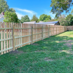 A long, newly installed wooden picket fence enclosing a backyard by Cutting Edge Contracting and Handyman in Minneapolis, MN.