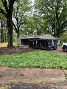 A Dts dumpster rentals container full of construction and yard debris at a residential job site in Memphis, TN.