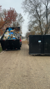 A full dumpster from MWT Dumpster and Hauling Services, loaded with general junk and debris, ready for removal in Morris, IL.