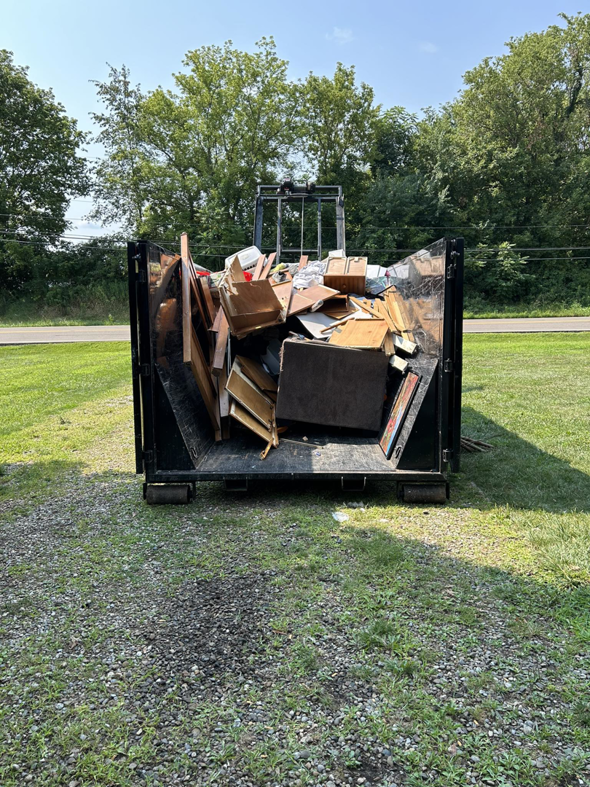 A Trash Hunter LLC dumpster completely full of various general junk items after a removal job in Hartville, OH.