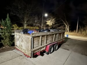 A dumpster trailer filled with various junk and debris, showing a completed junk removal job by Dumpster Kings LLC in Lansing, MI.