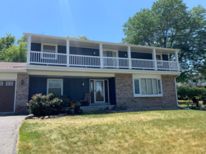 Full front view of a house with new dark blue siding and balcony by Sockett Siding, LLC in Milwaukee, WI