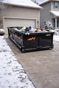 A large, full dumpster from JunkIt570 placed in a residential driveway after a junk removal service in Jessup, PA.