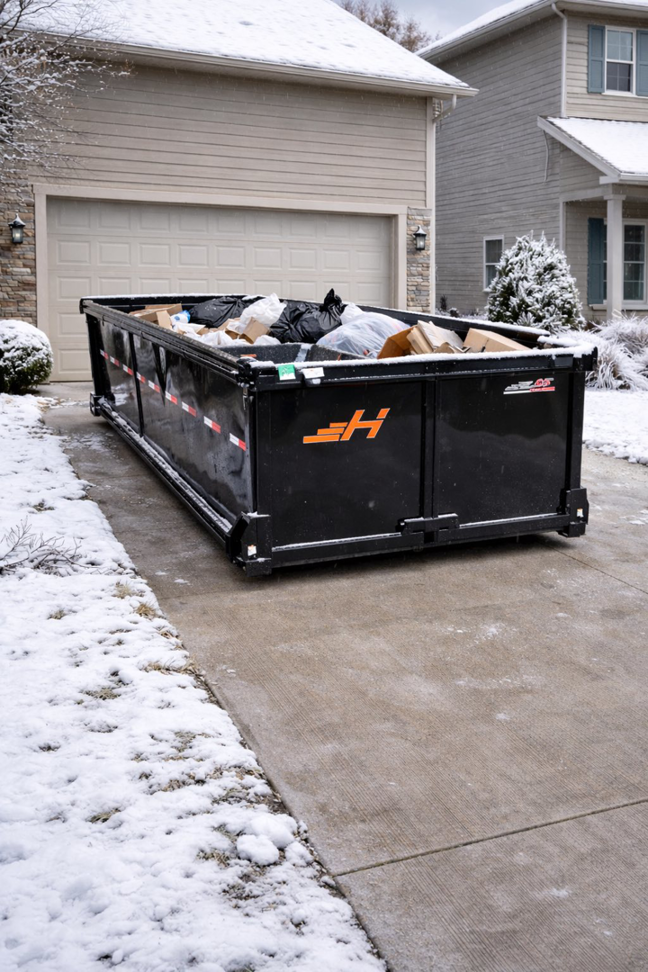 A large, full dumpster from JunkIt570 placed in a residential driveway after a junk removal service in Jessup, PA.