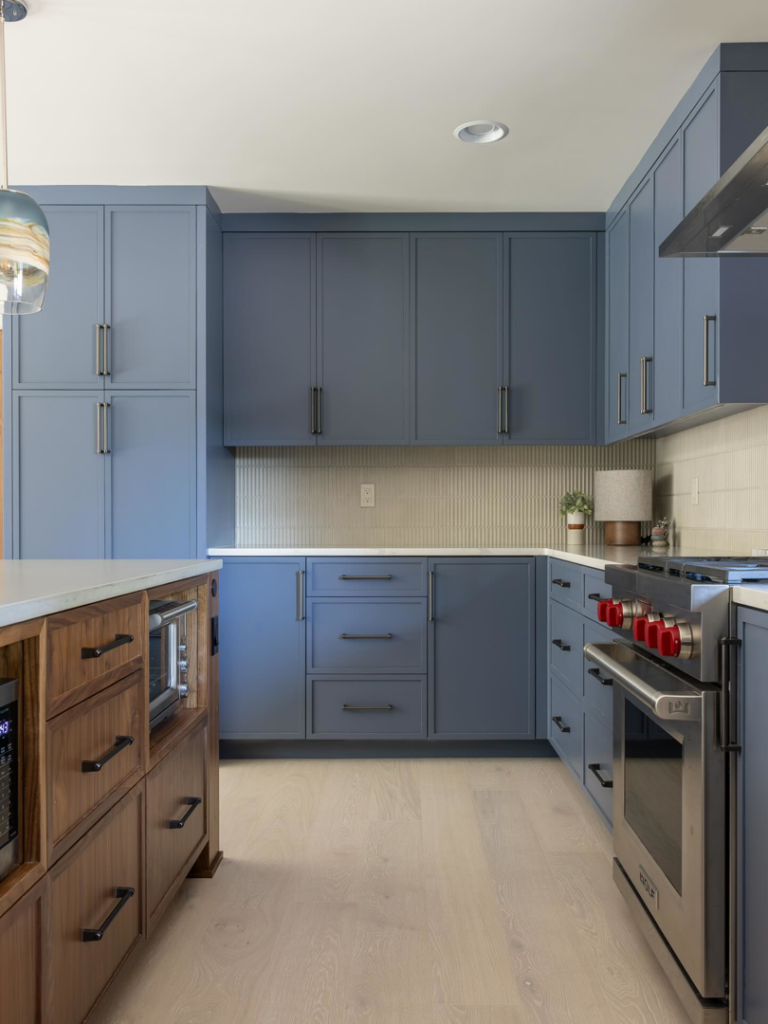A full kitchen remodel featuring blue cabinets, a wooden island, and new appliances by JDI Construction in Vancouver, WA.