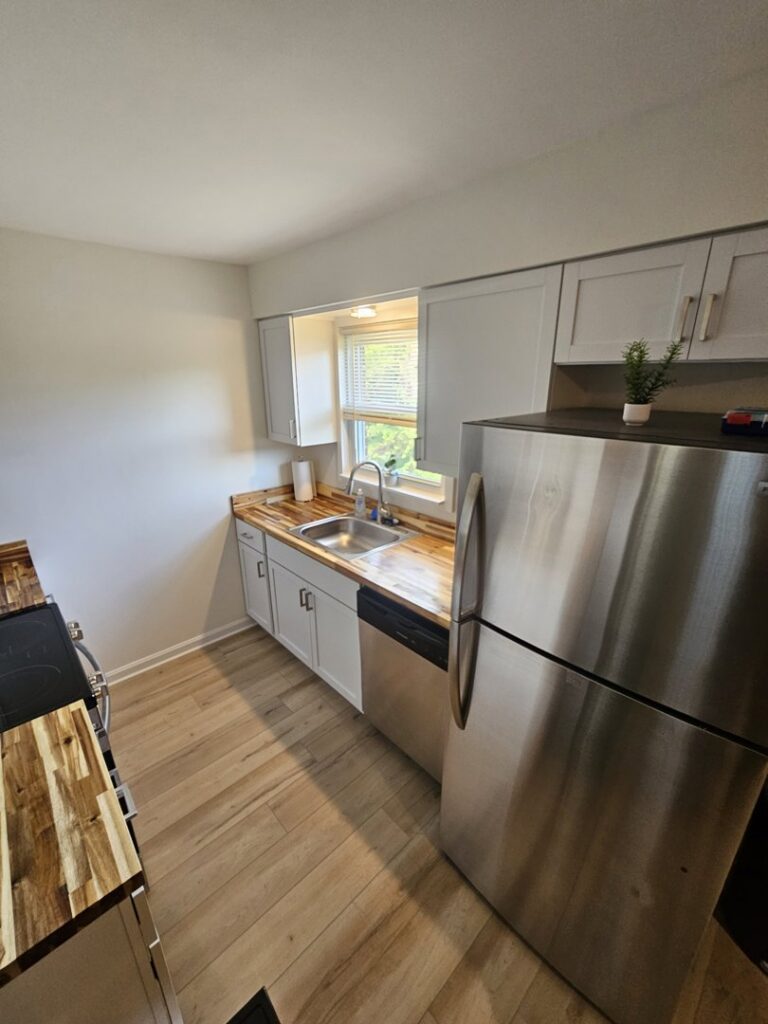 A full kitchen remodel showcasing new stainless steel appliances and wood countertops by Imperial Access Contracting in Evansville, IN.