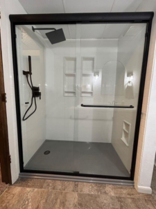 A full shower enclosure with a glass door and black frame installed by VanVleet Construction in Brooklyn Park, MN.