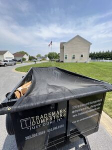 A full Trademark Dumpsters trailer, covered with a tarp, after a residential junk removal service in Wilmington, DE.