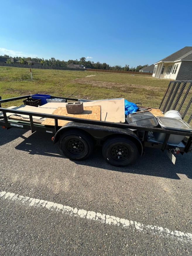 A wide shot of a utility trailer filled with construction waste and debris, ready for hauling by Resilient Trash and Cleaning LLC in New Orleans, LA.