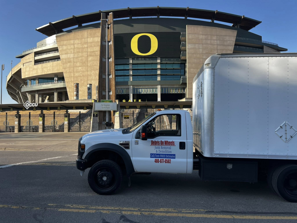A full side view of the Debris On Wheels branded junk removal truck in Eugene, OR.