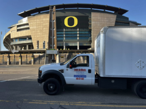 A full side view of the Debris On Wheels branded junk removal truck in Eugene, OR.