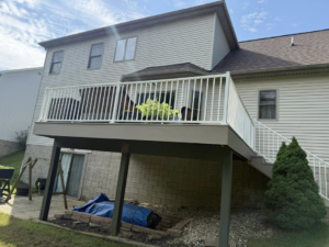 A full view of a newly built deck with white railings and stairs by Horstman Construction in Erie, PA.