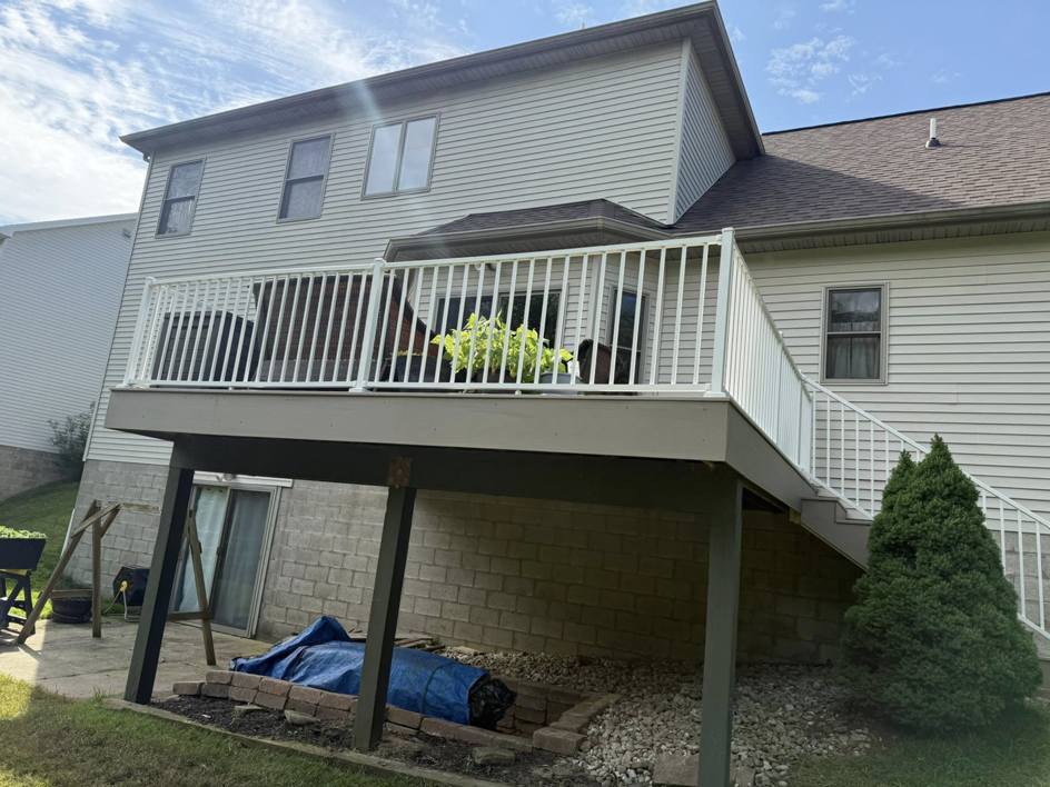 A full view of a newly built deck with white railings and stairs by Horstman Construction in Erie, PA.