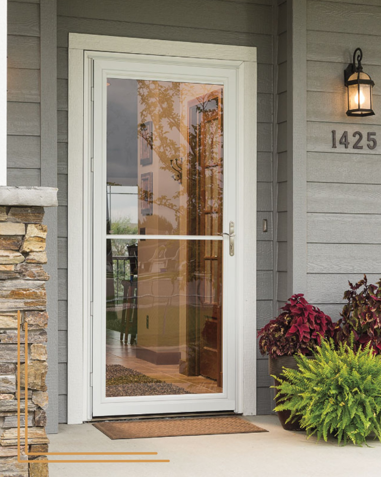 A clear full-view storm door installed on a gray house with visible house numbers by Denver Storm Door in Denver, CO.