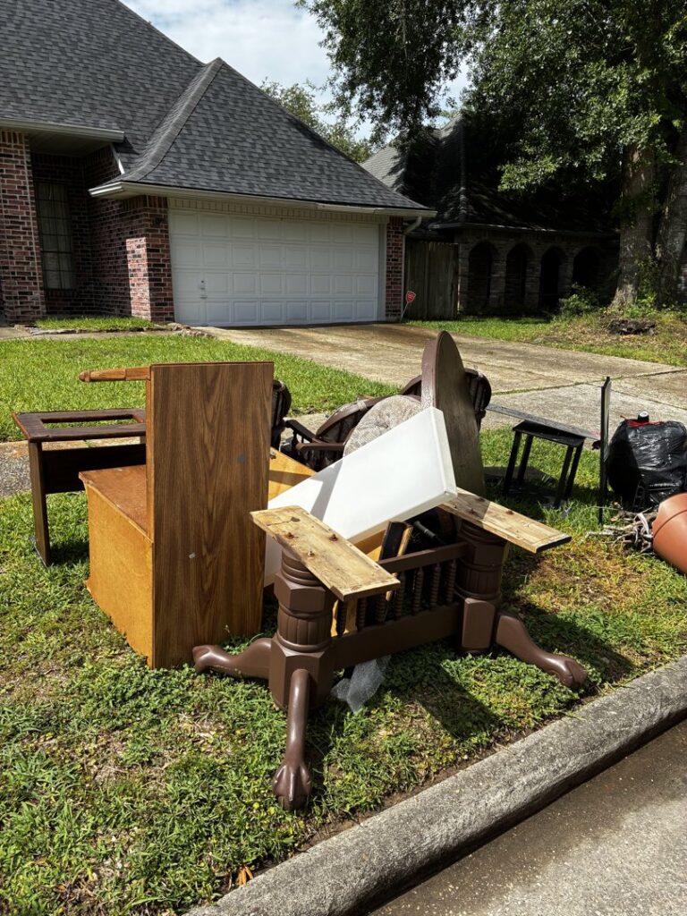 Old furniture and various household junk piled on a residential lawn, ready for Handymen Junk Removal in Houston, TX.