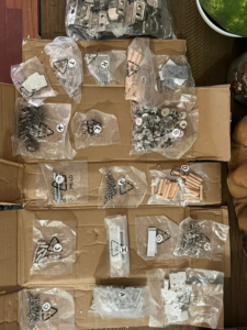 Various hardware components like screws, hinges, and dowels, neatly organized for furniture assembly by Assembly Required in Summerville, SC.