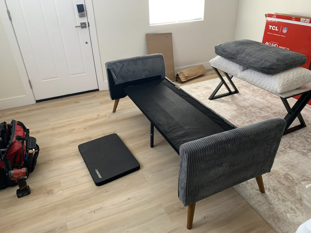 A partially assembled sofa with a handyman's toolbox nearby, showing furniture assembly in progress by Honest Handyman Service in Phoenix, AZ.