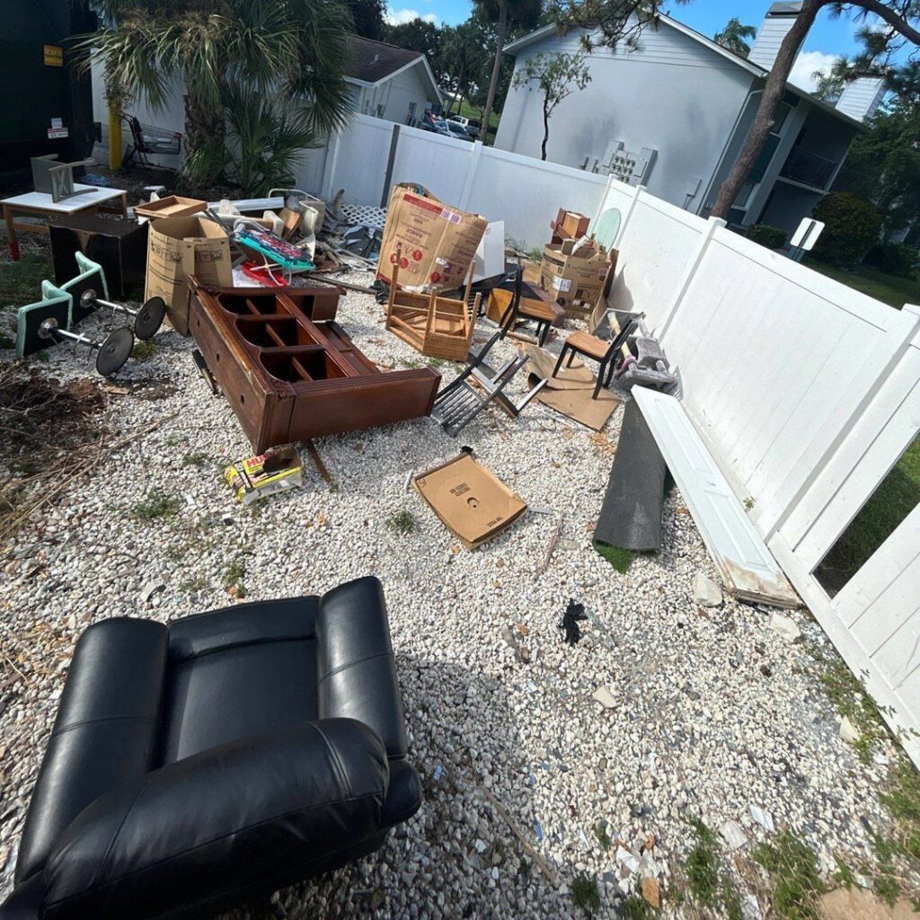 Furniture, boxes, and other household junk piled on gravel for removal by Veterans Easy Trash: Atlanta in Atlanta, GA.