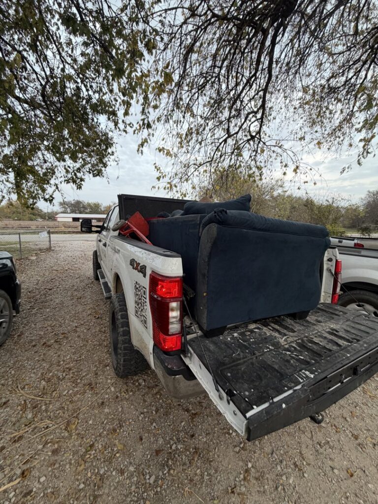 Two blue armchairs and a wooden cabinet placed curbside for junk removal by City to City Junk Removal Fort Worth, TX.