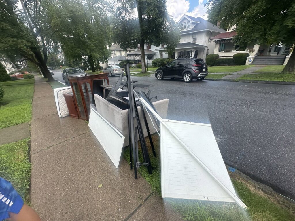 A large pile of old furniture and household items on a sidewalk, ready for general junk removal by Junken Monkeys Hauling Company in Scranton, PA.