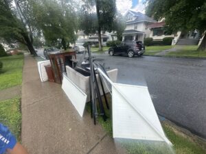 A large pile of old furniture and household items on a sidewalk, ready for general junk removal by Junken Monkeys Hauling Company in Scranton, PA.