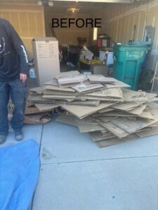 A garage entrance with a large pile of cardboard boxes before a junk removal service by Tiny Monster Junk Removal LLC in Denver, CO.