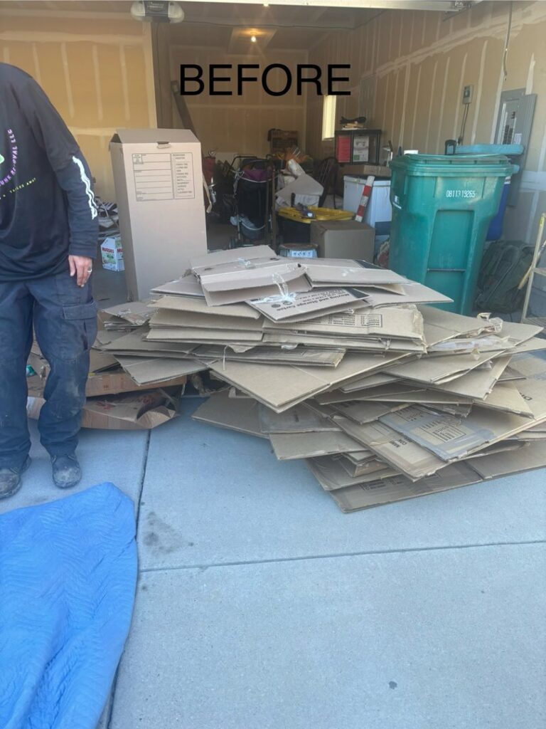 A garage entrance with a large pile of cardboard boxes before a junk removal service by Tiny Monster Junk Removal LLC in Denver, CO.