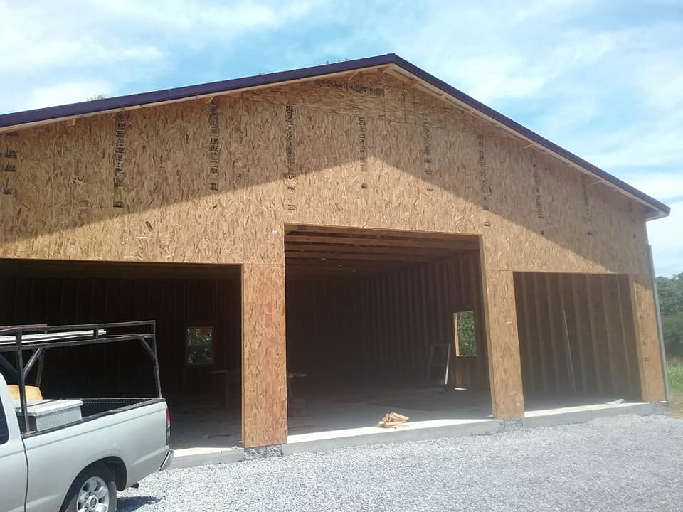 A large garage building under construction with OSB sheathing, a project by The House Doctor in Hopkinsville, KY.
