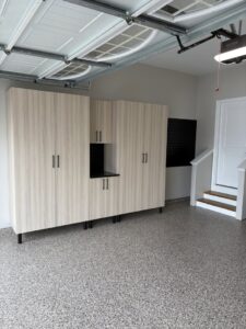 Custom garage cabinets with a black slatwall section installed by PremierGarage of Baltimore in Baltimore, MD.