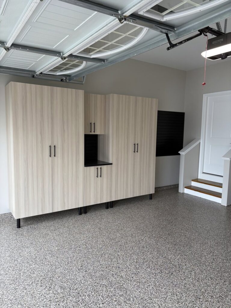 Custom garage cabinets with a black slatwall section installed by PremierGarage of Baltimore in Baltimore, MD.